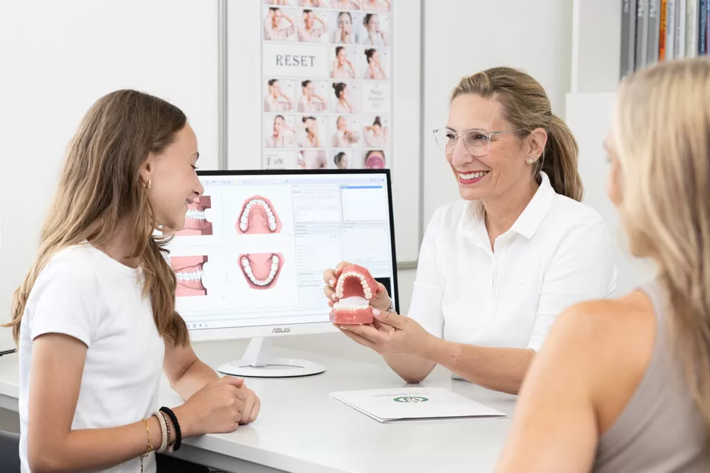 Dr Paula Göser discusses holistic orthodontic care with a mother and daughter